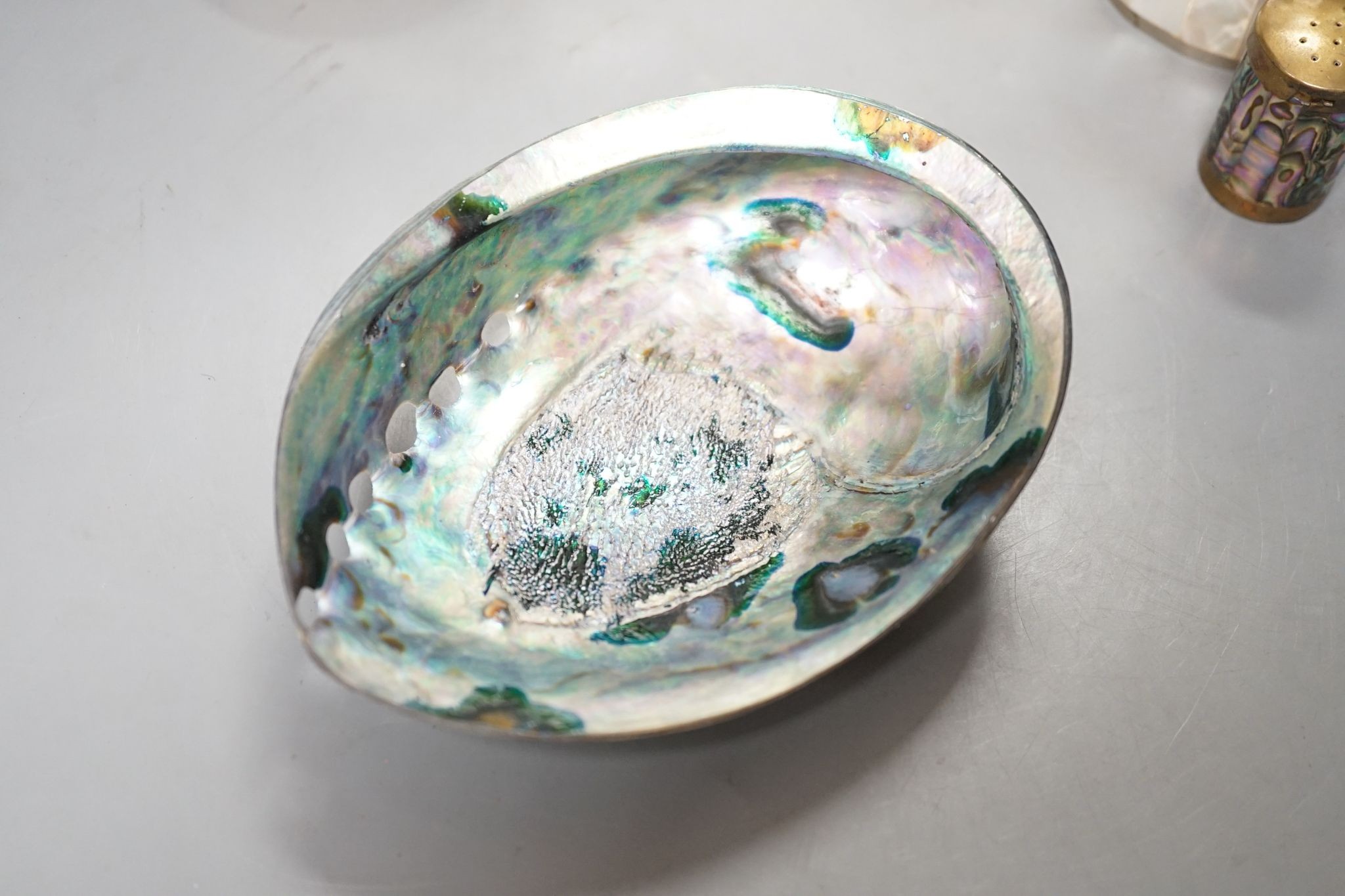 An engraved pearl shell, 22cm, a cylindrical box and bracelet, and two abalone shells